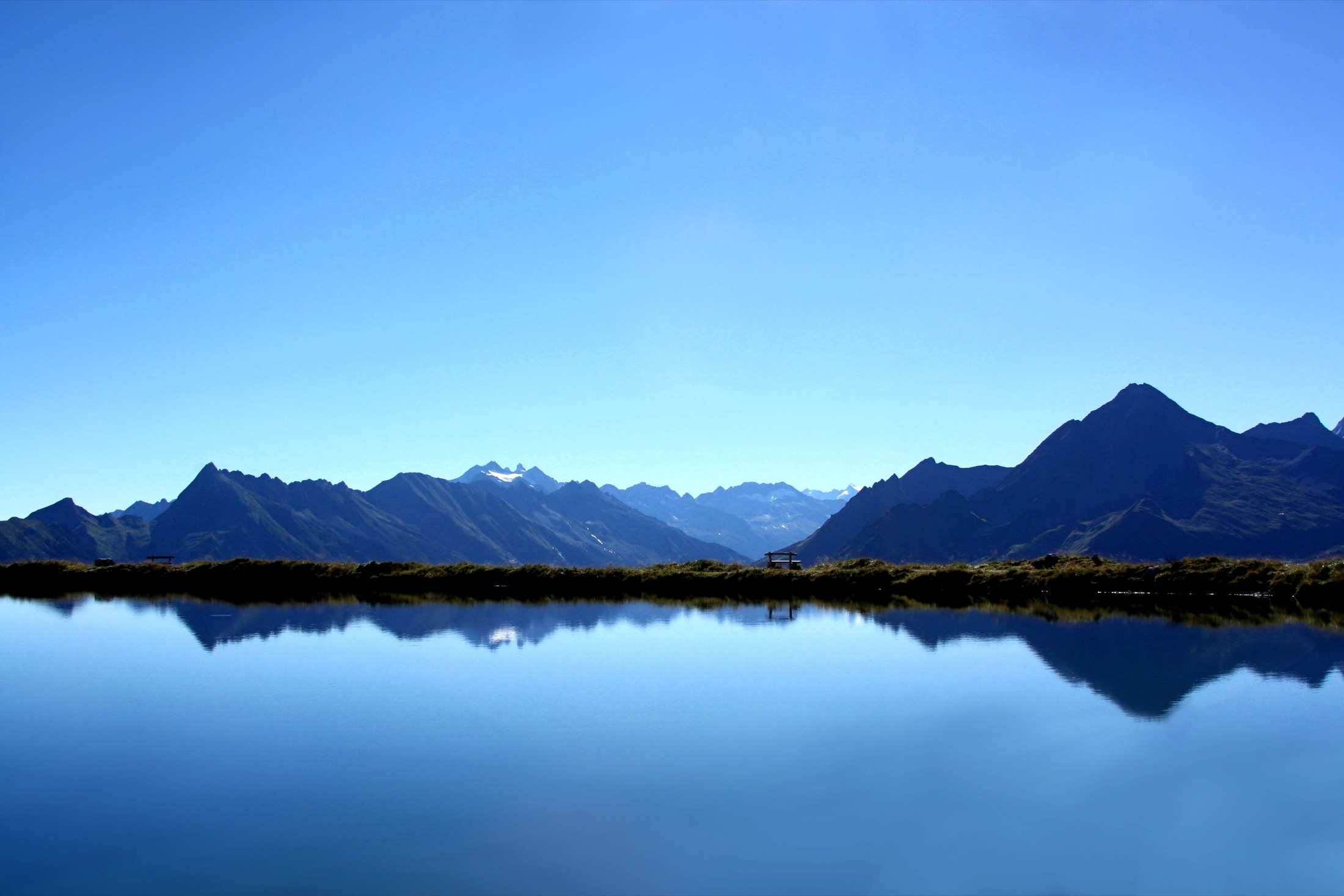 Lac de montagne dans les Alpes avec sommets en arriere-plan